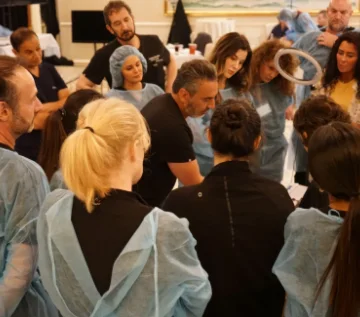 Dr. Saadat surrounded by students observing his demonstration